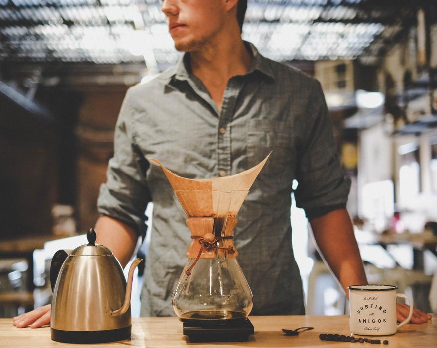 man in front of a kettle of coffee